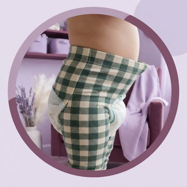 Close-up of bamboo baby leggings with bison plaid pattern showing the stretchy waistband fit over a cloth diaper.